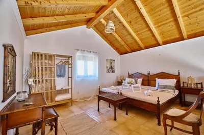 a bedroom with a bed and a desk and a table at La Maison to Chani in Stílos