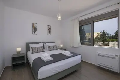 a bedroom with a large bed and a window at Almyrida Hills Villas in Koprána
