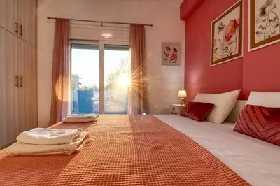 a bedroom with a large bed with red walls at Magedico 150m from the beach in Kissamos