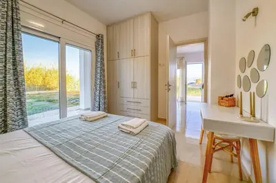 a bedroom with a bed and a desk and a window at Magedico 150m from the beach in Kissamos