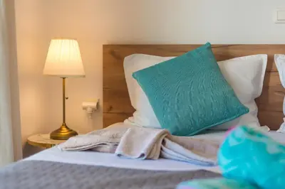 a bed with a green pillow and a lamp at Almyrida Bay View House II BY APOKORONAS-VILLAS in Almirida