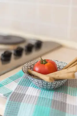 a tomato in a bowl on a table with chopsticks at Almyrida Bay View House II BY APOKORONAS-VILLAS in Almirida
