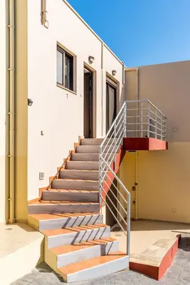 a staircase with a metal railing next to a building at Almyrida Bay View House II BY APOKORONAS-VILLAS in Almirida