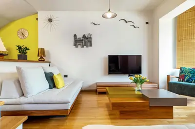 a living room with a couch and a tv at La Casa Di Fiori Stylish Holiday Home in Plataniás