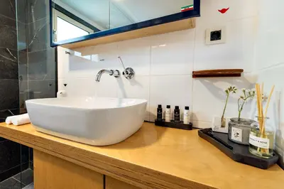 a bathroom with a large white sink on a counter at La Casa Di Fiori Stylish Holiday Home in Plataniás