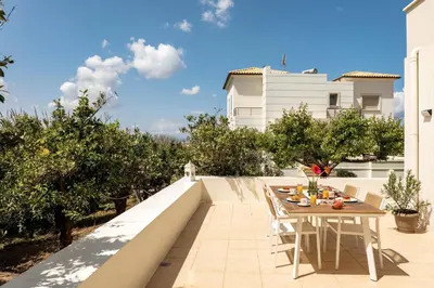 a patio with a table and chairs on a balcony at La Casa Di Fiori Stylish Holiday Home in Plataniás