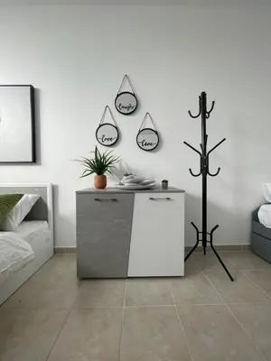 a white room with a table and a bed at AIOLOS Chania center luxury apartment near the garden in Chania Town