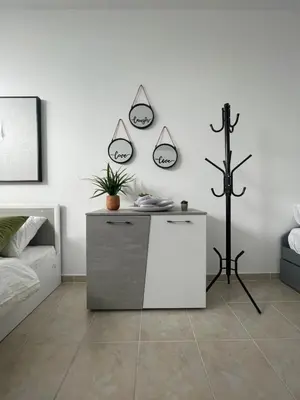 a white room with a bed and a table at AIOLOS Chania center luxury apartment near the garden in Chania Town
