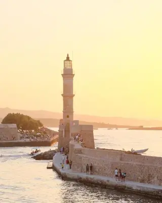 a lighthouse in the water next to a body of water at Splatzia old town house in Chania Town