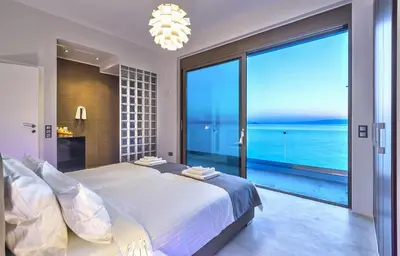 a bedroom with a large bed and a large window at Luxury seafront design villa Kyma in Tersanas Owner listing in Tersanas