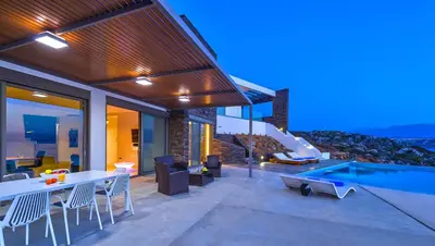 a patio with a table and chairs and a swimming pool at Luxury seafront design villa Kyma in Tersanas Owner listing in Tersanas