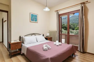 a bedroom with a bed with pink sheets and a window at Garden House with Pool, 10min to center in Nerokoúros