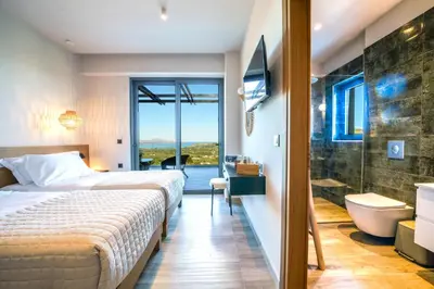 a bedroom with a bed and a bathroom with a shower at In Vivo Villa - Breathtaking View -90sqm Heated Infinity Pool in Áyios Pávlos