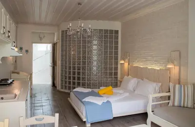 a bedroom with a bed and a table and a chair at Alkionides Seaside Hotel in Plataniás