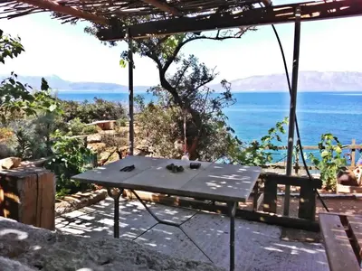 a picnic table with a view of the ocean at 2 annexed apartments -Private place to swim-large terrace- Unlimited view in Ravdhoúkha