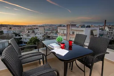a table and chairs on a balcony with a view at Nikolas City Home in Chania Town