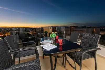 a table and chairs on a balcony with a view at Nikolas City Home in Chania Town
