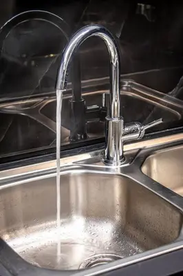 a kitchen sink with water running from a faucet at Nikolas City Home in Chania Town