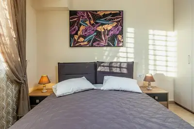a bedroom with a bed with two lamps and a painting at Nikolas City Home in Chania Town
