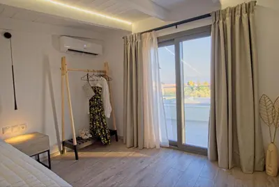 a bedroom with a bed and a sliding glass door at Villa Mourelo luxury villa in chania with private pool jacuzzi in Chania Town