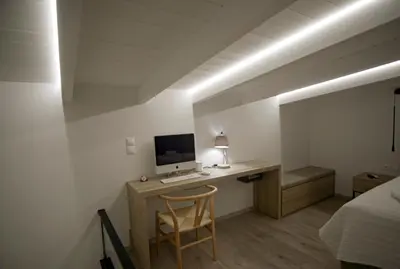 a bedroom with a desk with a computer and a bed at Villa Mourelo luxury villa in chania with private pool jacuzzi in Chania Town