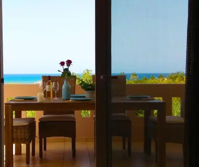 a dining room with a table and a view of the ocean at Stelia Apartment Gerani in Ayiá