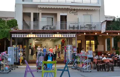 a store front with tables and chairs in front of a building at Corali Studios in Palaiochóra
