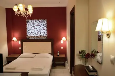 a bedroom with a white bed and a red wall at Corali Studios in Palaiochóra