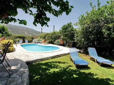two chairs and a swimming pool in a yard at Villa Ovgoro, Provarma, pool, seaview balcony in Próvarma