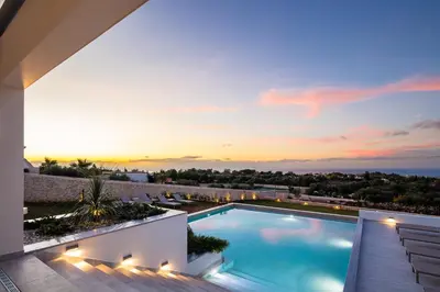 a villa with a swimming pool at sunset at Villa St John - Wellness & Entertainment by etouri in Chania Town
