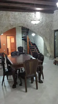 a dining room with a wooden table and chairs at Venetian Cistern Villa in Kalamítsion Alexándrou