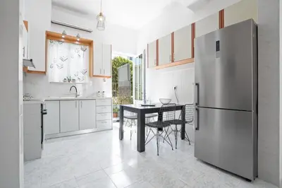 a kitchen with a stainless steel refrigerator and a table at Elie's House next to the beach in Chania Town
