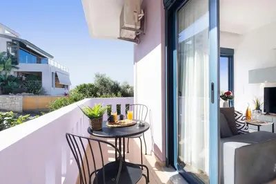 a balcony with a table and chairs on a balcony at Home Philip III in Chania Town