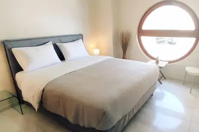 a bedroom with a large bed with a large window at Chrysa Apartments in Chania Town