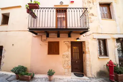 a building with a balcony and a door at Athena's House in Chania Town