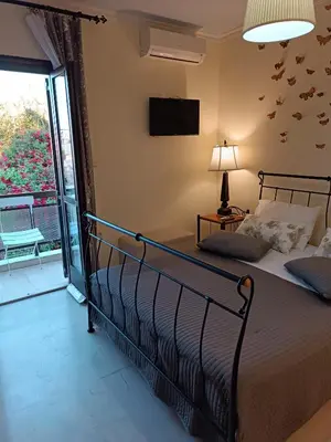 a bedroom with a bed and a tv on the wall at Rayon De Soleil in Chania Town