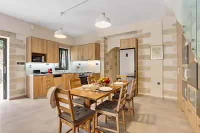 a kitchen with a wooden dining room table and chairs at Brand new Villa Volakas BY APOKORONAS VILLAS in Gavalochori