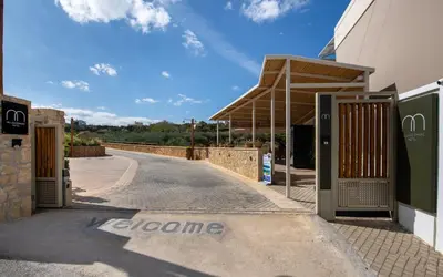 a building with two gates and a road at Villaggio Mare Suites in Kalamaki Chanion