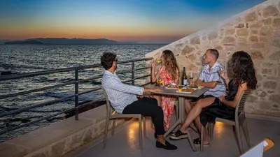 a group of people sitting at a table on a cruise ship at Hippocampo Waterfront Villa in Chania Town