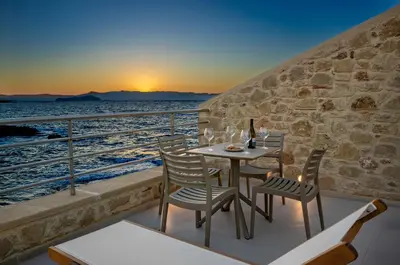 a table and chairs on a balcony with a view of the ocean at Hippocampo Waterfront Villa in Chania Town