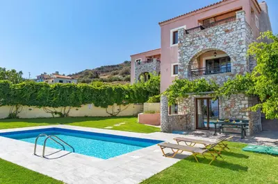 a villa with a swimming pool in front of a house at Villa Forteza in Kalami