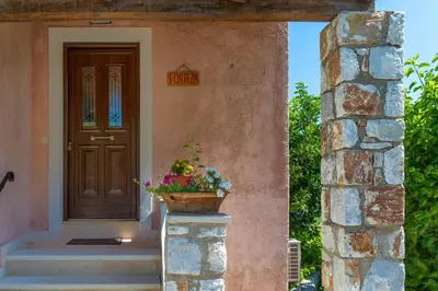 a door of a house with a flower pot on a pillar at Villa Forteza in Kalami