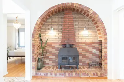 a brick fireplace in the middle of a living room at Suncatcher House by 8essentially in Chania Town