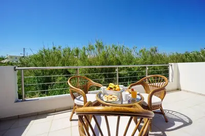 a table with a bowl of fruit on a balcony at Geas House Ammos in Kolymvari