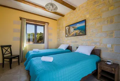 two beds in a room with a stone wall at Villa Aliki - Traditional stone house with maximum privacy and stunning views ! in Xamoudhokhórion