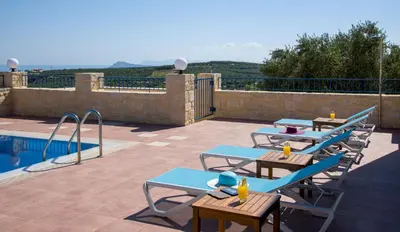 a row of picnic tables next to a swimming pool at Villa Aliki - Traditional stone house with maximum privacy and stunning views ! in Xamoudhokhórion