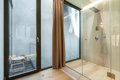a bathroom with a shower and a glass door at Poem Suites in Chania Town