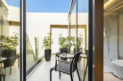 a balcony with a table and chairs and plants at Poem Suites in Chania Town