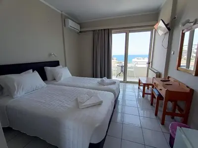 a hotel room with two beds and a view of the ocean at Kumba in Nea Chora in Chania Town