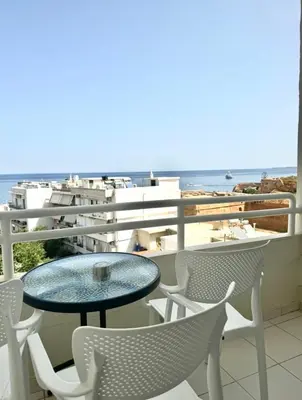 a table and chairs on a balcony with the beach at Kumba in Nea Chora in Chania Town